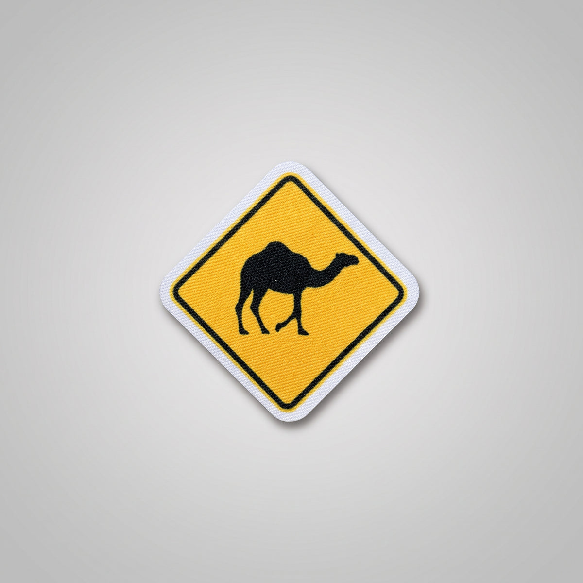 Yellow diamond road sign fabric patch with camel