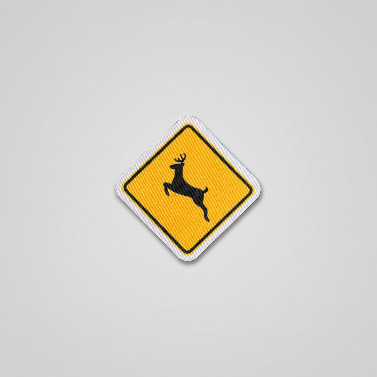 Yellow diamond road sign fabric patch with leaping deer
